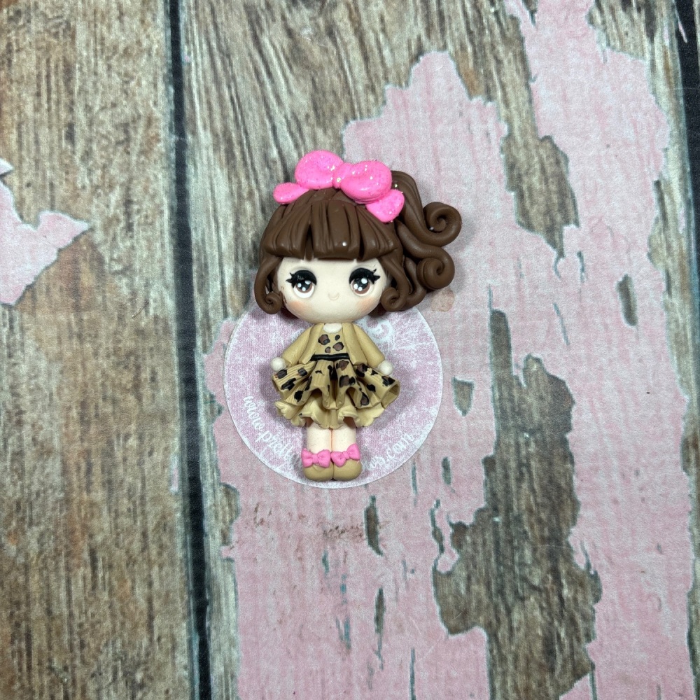 Little Girl with leopard print dress and beige jacket brown hair and pink hair bow