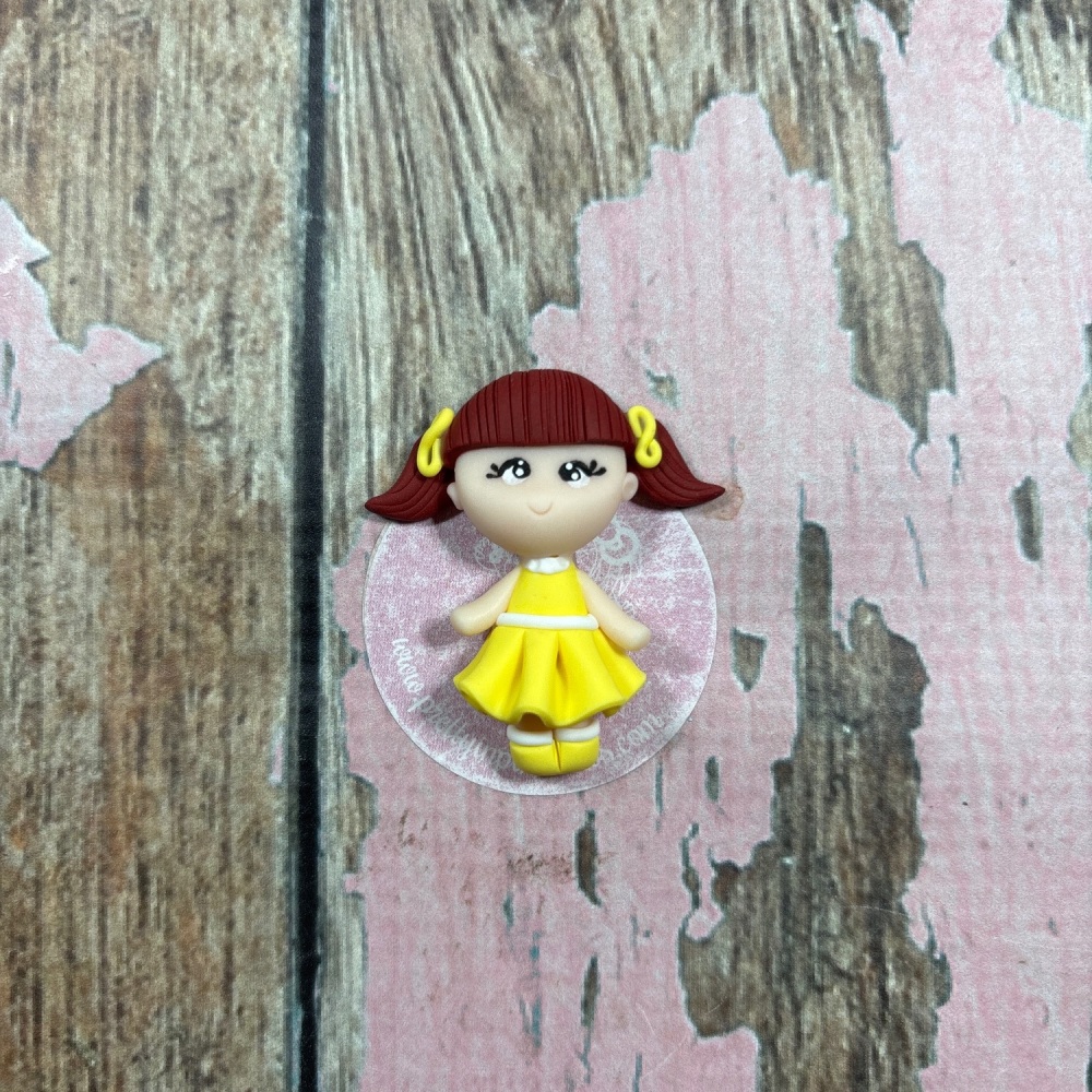 Little Girl in a yellow dress with brown hair and two yellow hair bows
