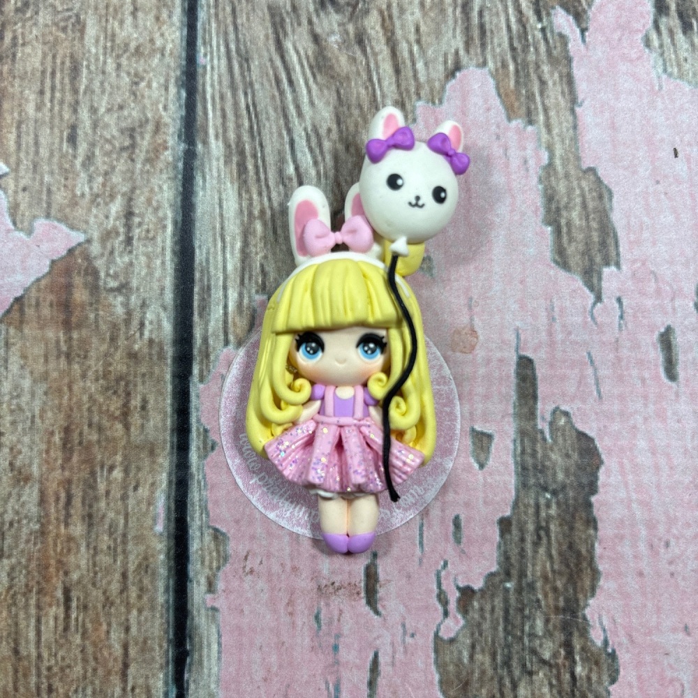 Little Girl in a pink dress with bunny ears and holding a rabbit balloon