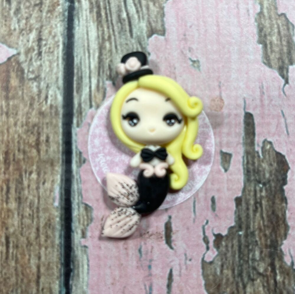 Little girl with a black top hat, black mermaid tail and blonde hair