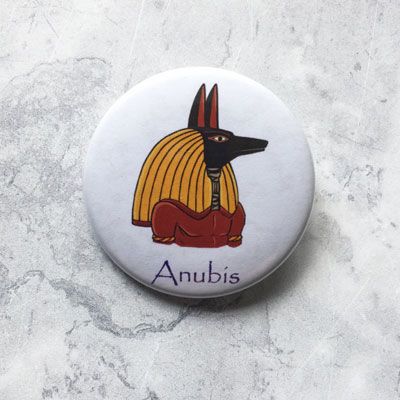 A round white badge with an image of Anubis.