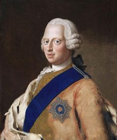 Frederick in a white wig with a tan coat and blue sash