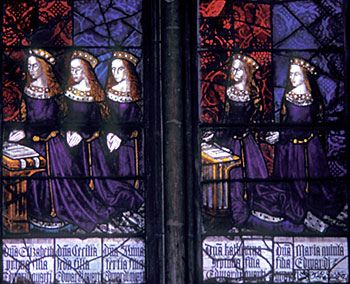 A stained glass window depicting five of King Edward 4th's daughters, kneeling in prayer.
