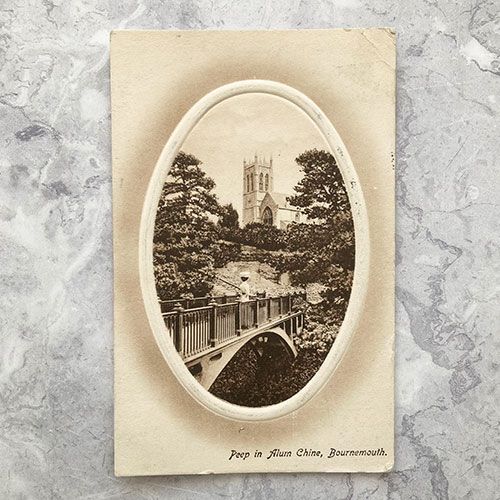 A vintage postcard with a photo of a bridge and a church.