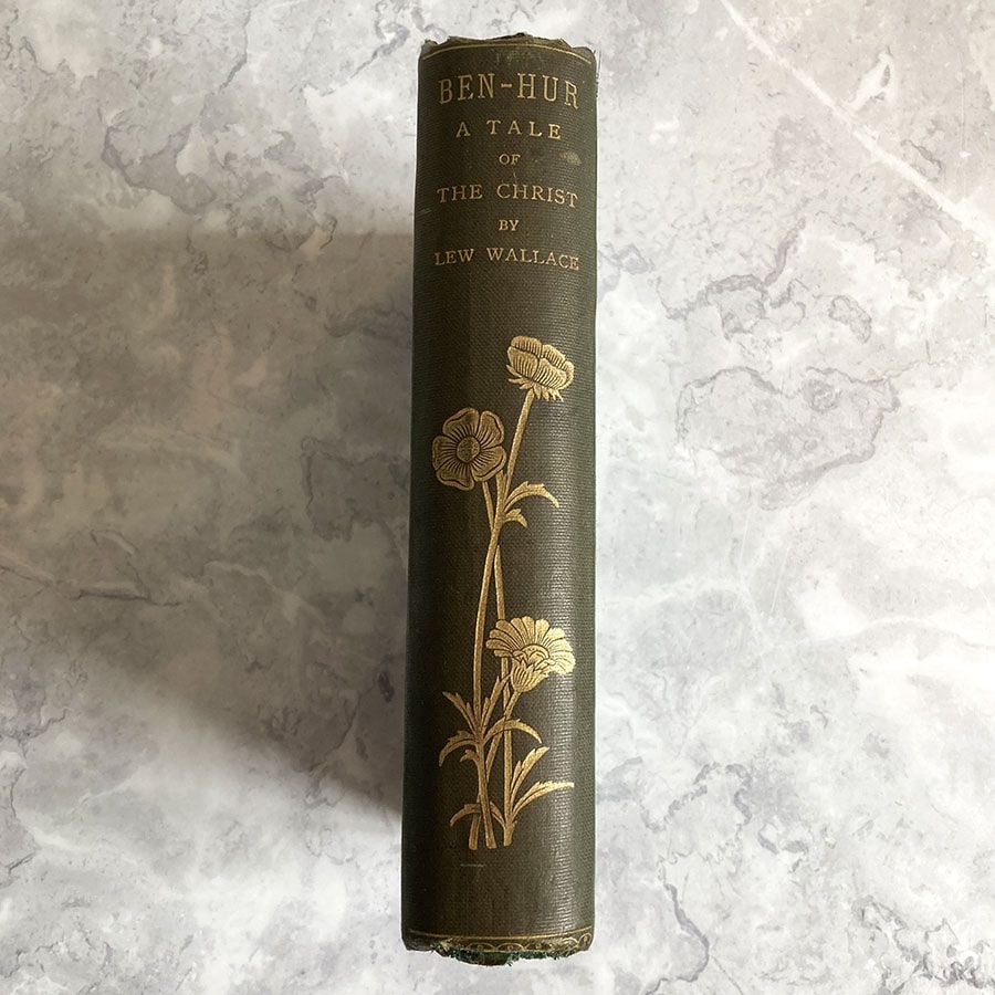 Spine of a vintage book with gilt flowers.