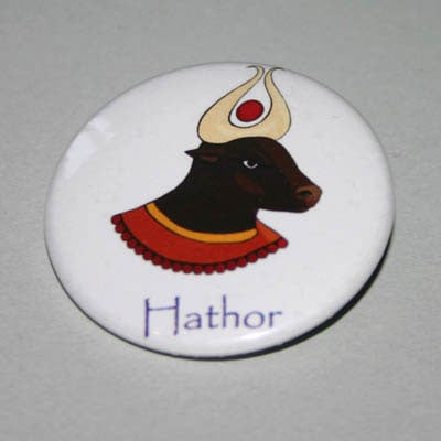 A round white badge with an image of Hathor.