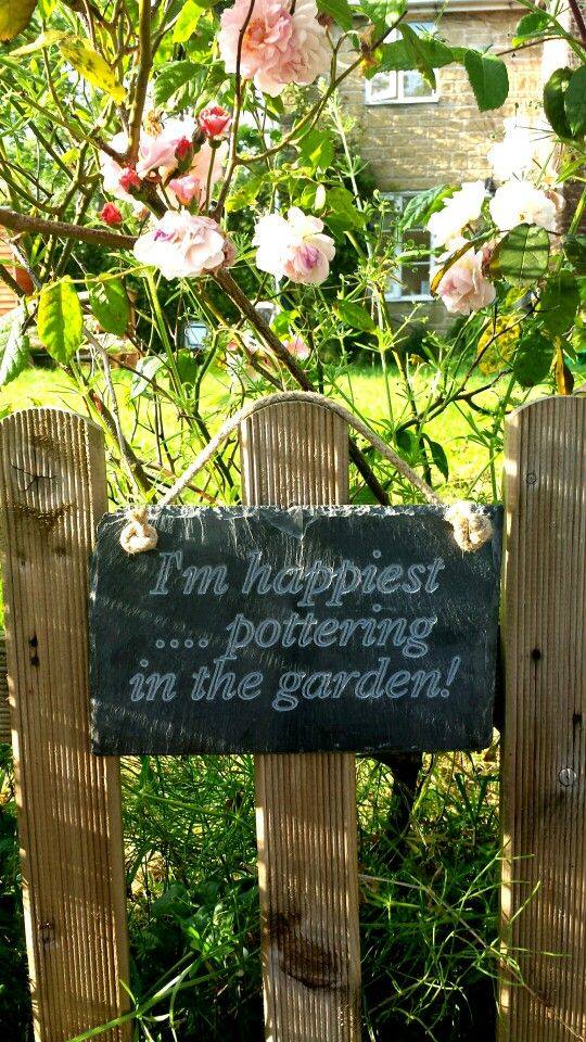 A beautiful slate sign that reads 'I'm happiest ... pottering in the garden
