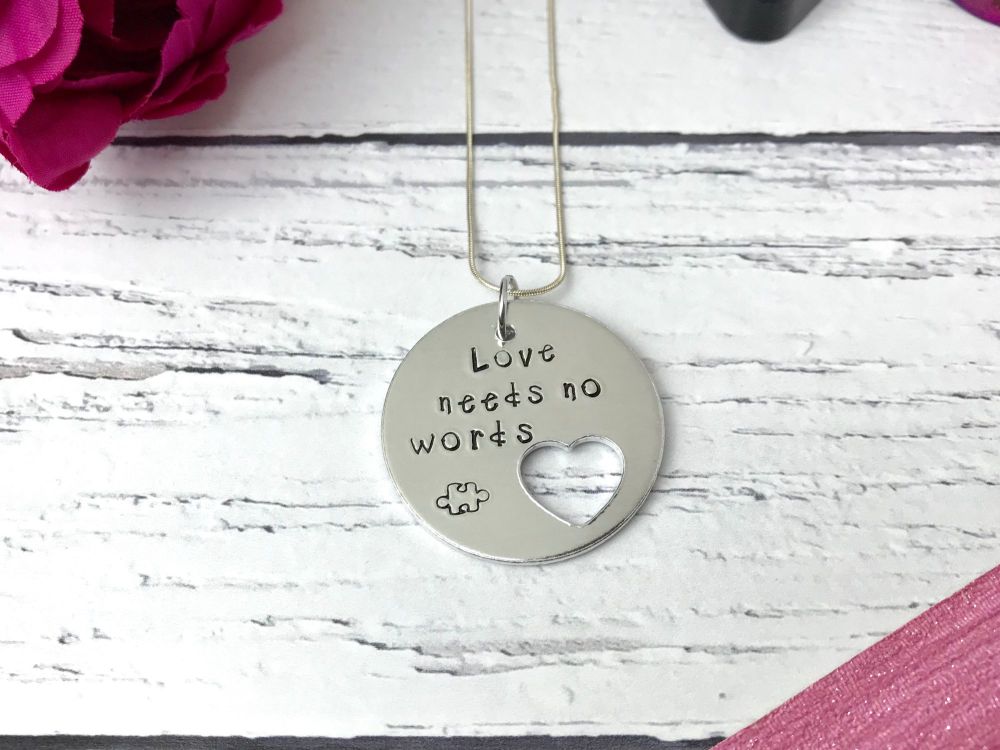 'Love needs no words' disc necklace with heart cut out