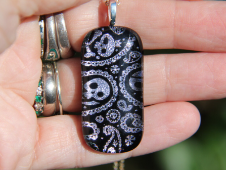 Silver skull and crossbones dichroic glass pendant