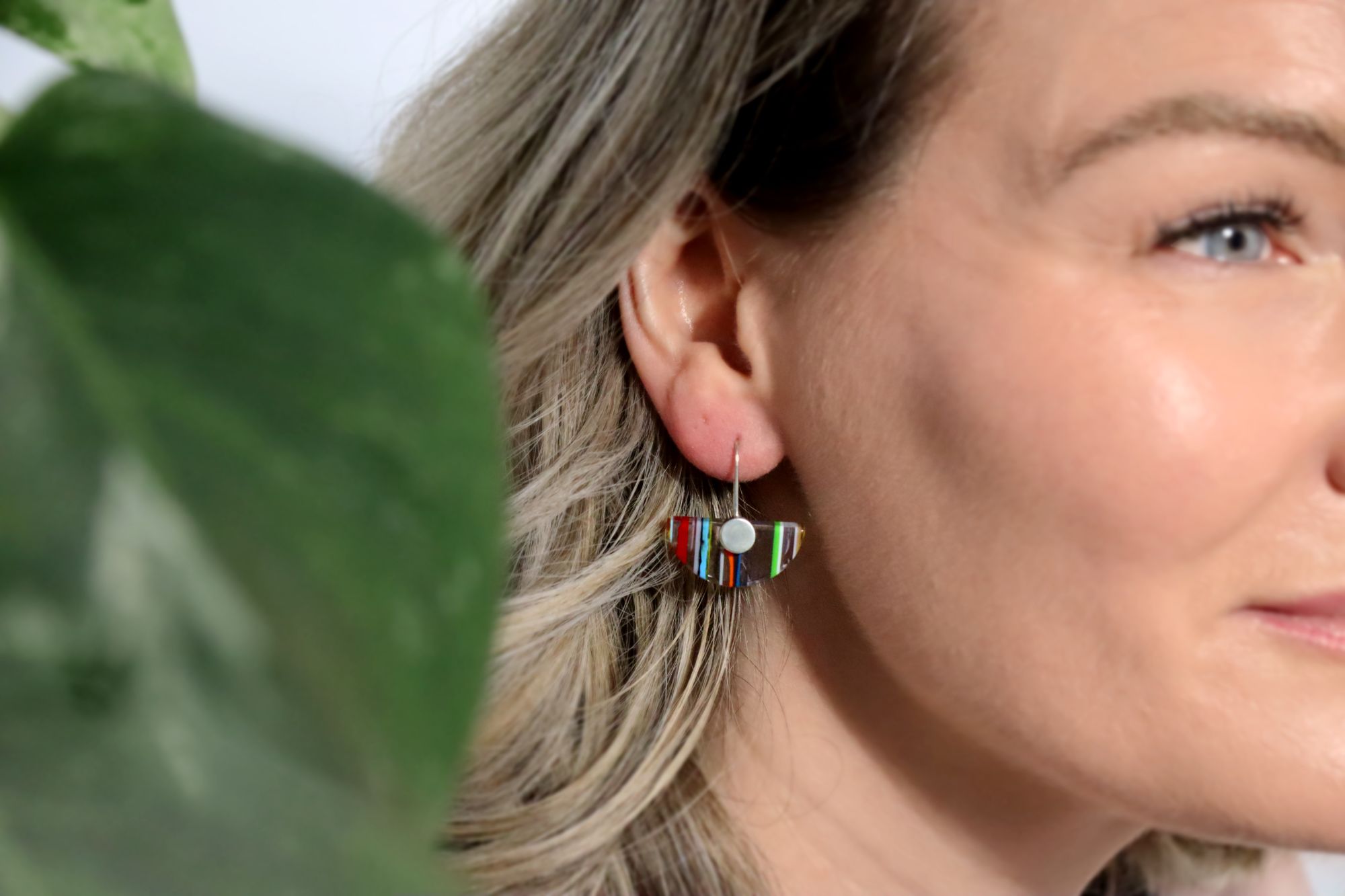 Women wearing a striped resin and silver earring