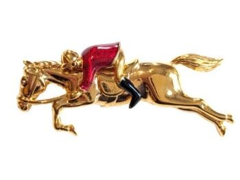 Vintage Cabouchon  brooch depicting a galloping horse and a jockey with gold plating and red and black enamel