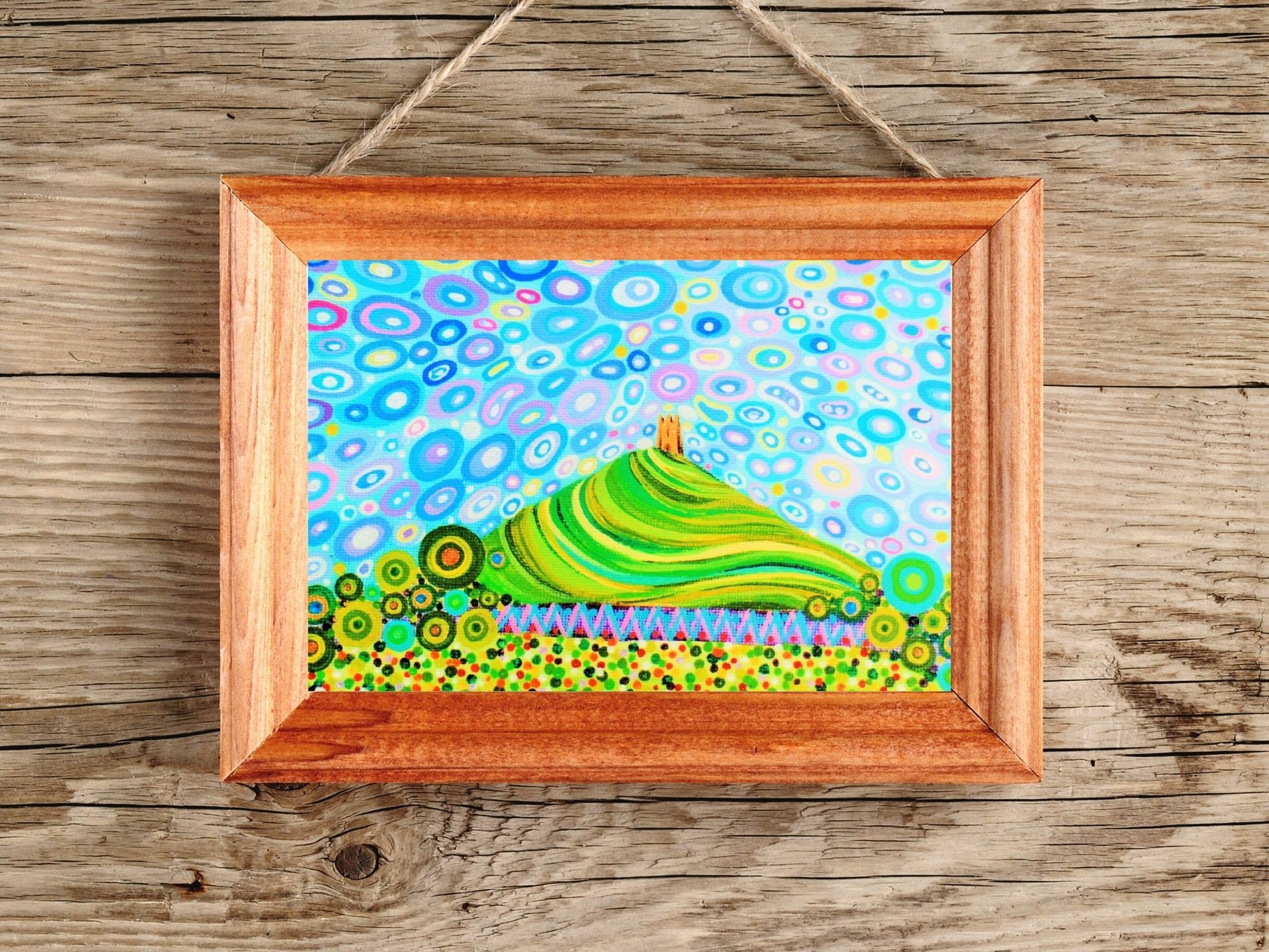 A colourful abstract art print of Glastonbury Tor, download and printable at home, in a wood effect frame (not available to purchase)