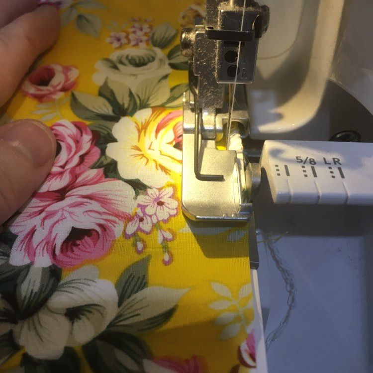 Overlocking machine on a fabric with a rose design on a  bright golden  background
