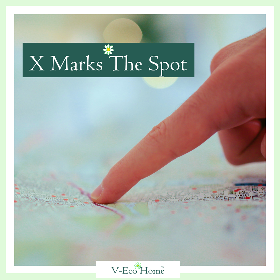 Finger pointing to a place on a map with wording X marks the spot