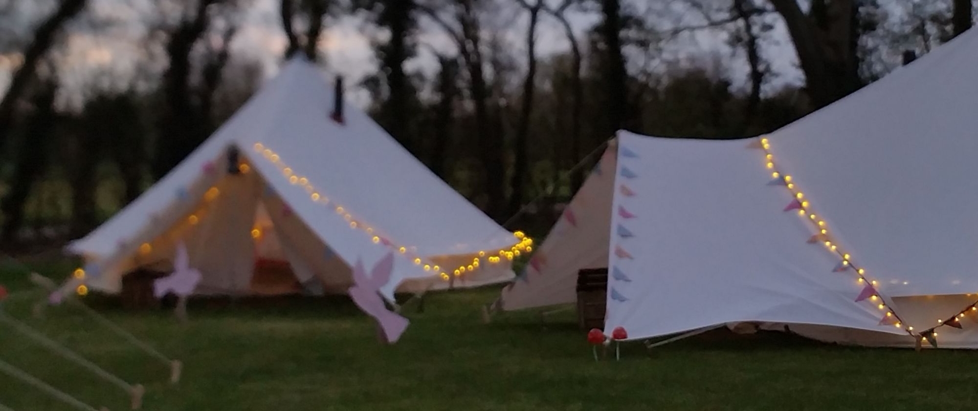 fairy lights at dusk on bell tents