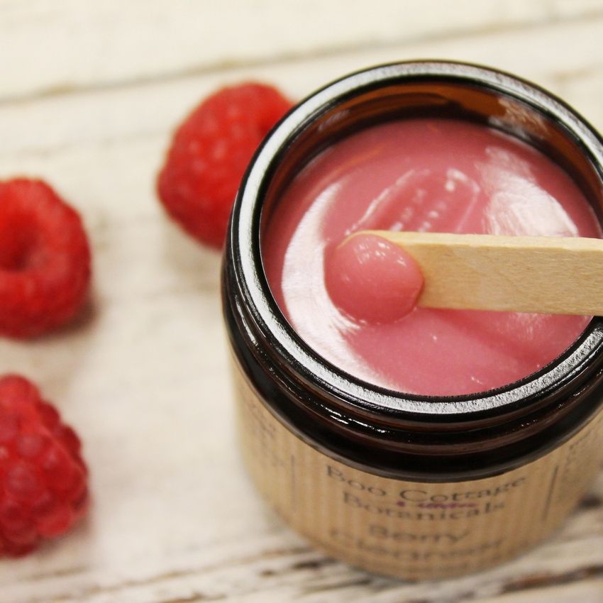 Pink Berry Cleanser in amber jar with wooden spatula stood in open pot.