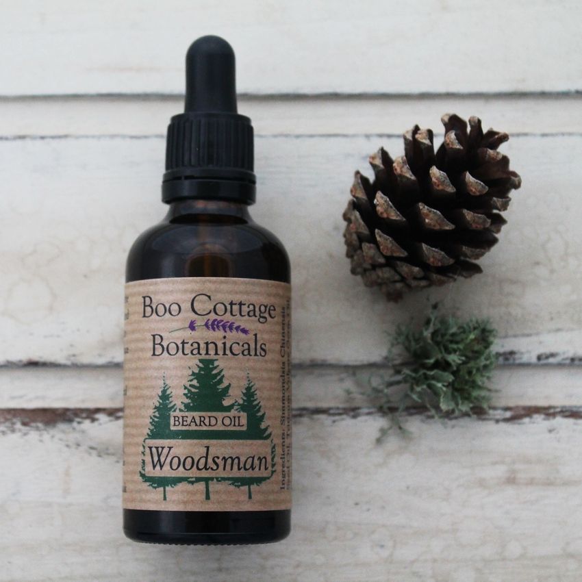 Woodsman beard oil in brown amber bottle with pipette.