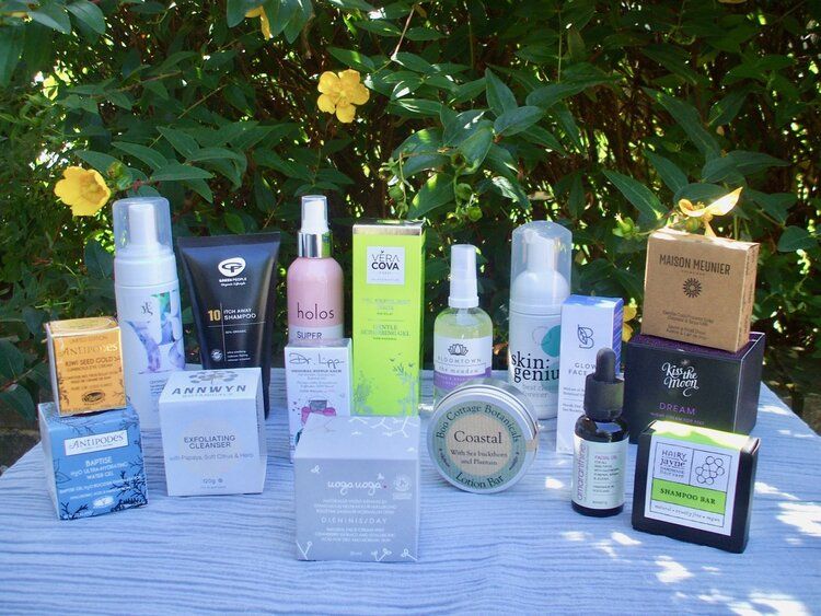Collection of winning products from 2020 Free From Skincare Awards on table in garden