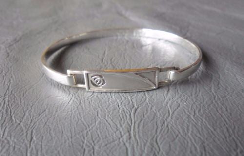 Sterling silver bangle with a cut-out rose panel
