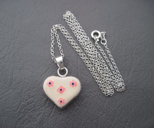 Sterling silver necklace with a floral cream enamel heart pendant
