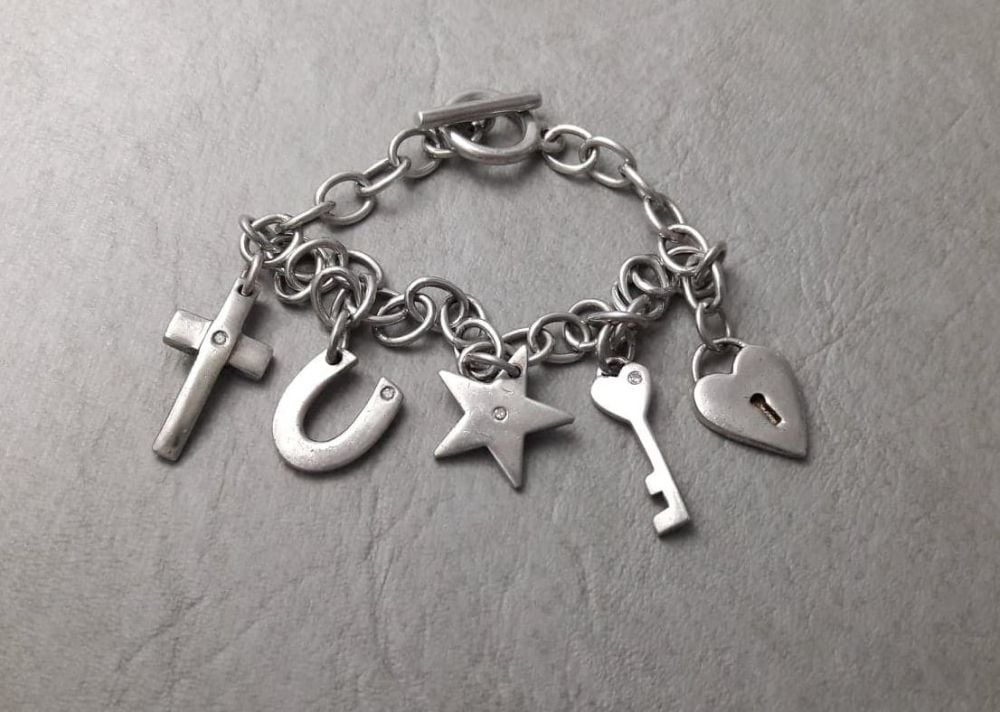 Sterling silver charm bracelet; padlock, star, key, horseshoe & cross
