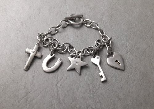 Sterling silver charm bracelet; padlock, star, key, horseshoe & cross