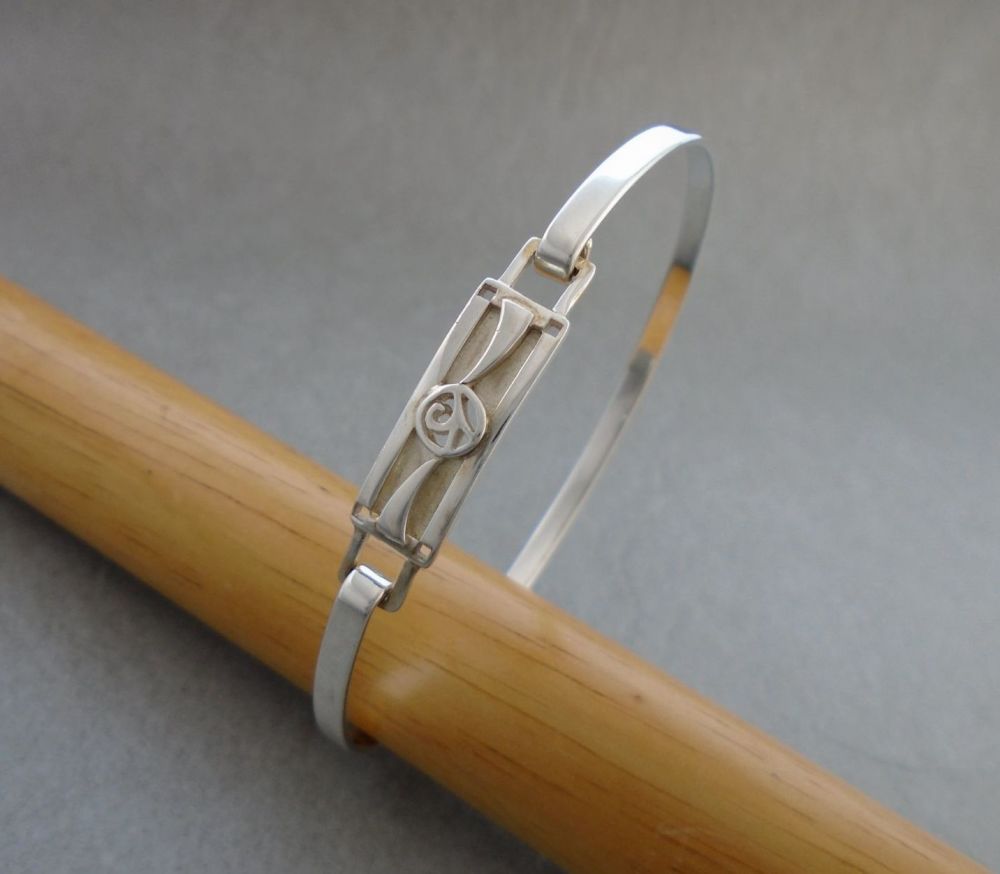 Sterling silver bangle with a small fancy panel