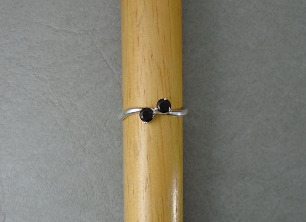 Gently waved sterling silver ring set with 2 black stones