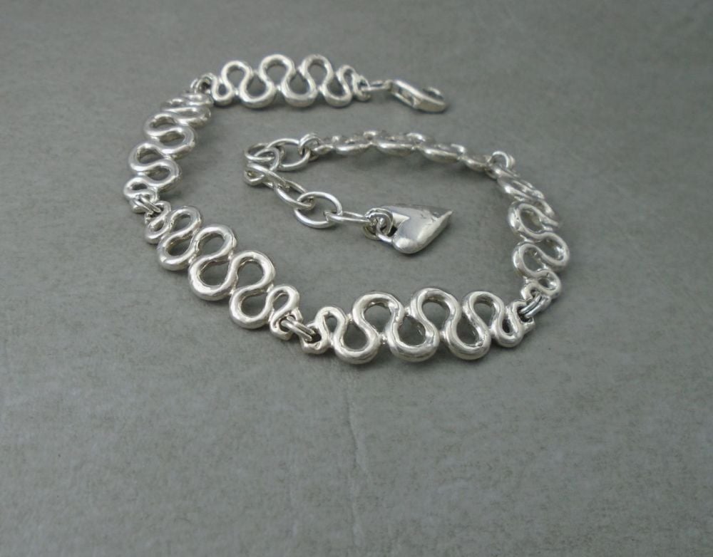 Sterling silver bracelet with smooth wavy panels & heart tag