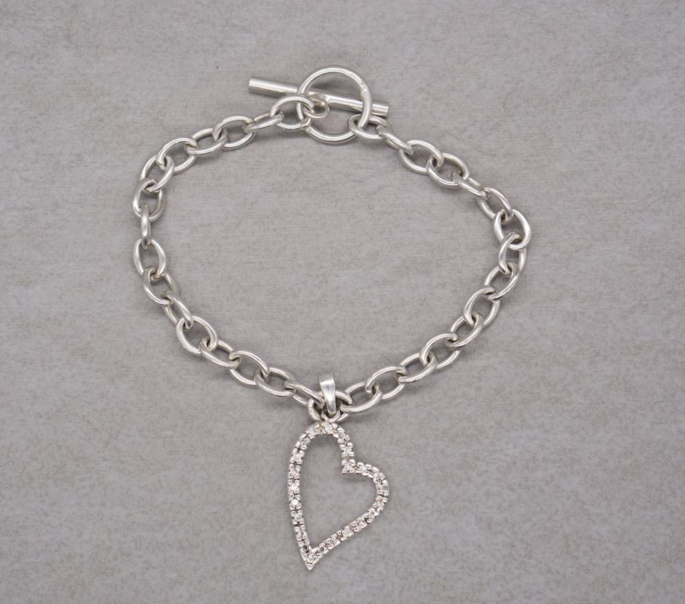 Sterling silver trace chain toggle bracelet with a clear stone heart charm