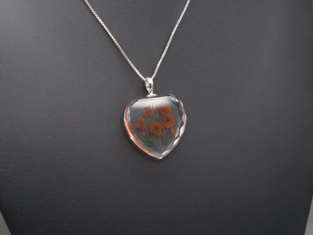 Sterling silver necklace with a faceted crystal heart pendant, poppy flower