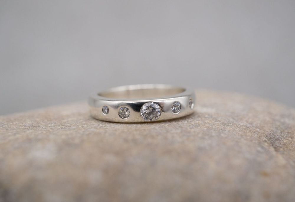 Sterling silver ring with 5 flush-set graduated clear stones