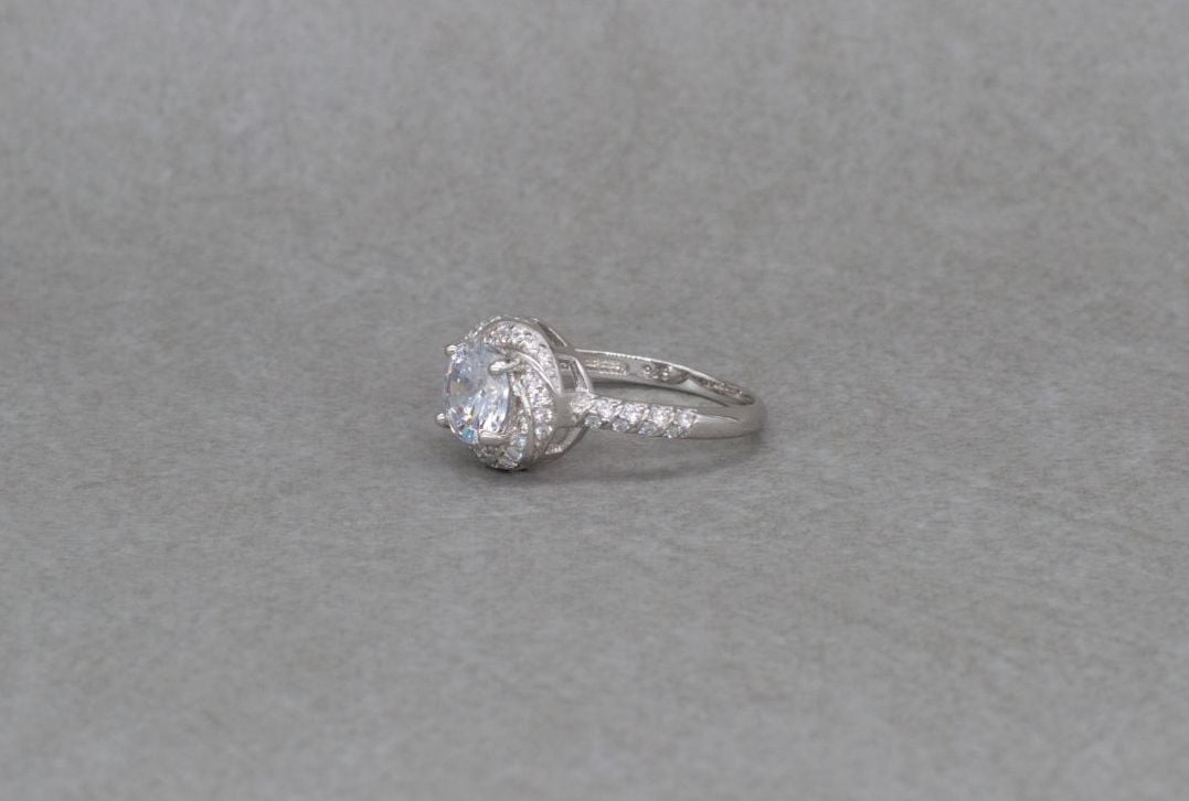 Sterling silver swirl mounted solitaire ring with accents