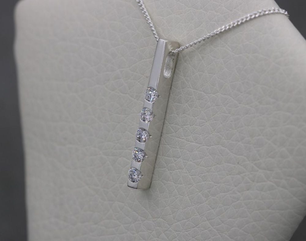 Sterling silver necklace with a slim, clear stone pendant
