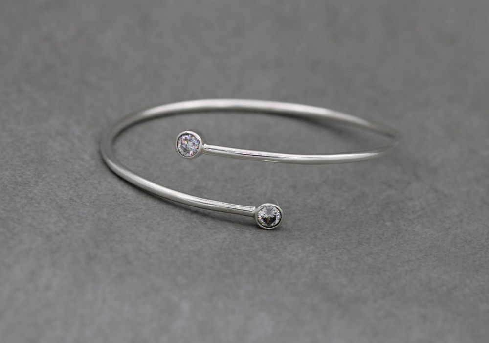 Sterling silver bypass bangle with faceted clear stone tips