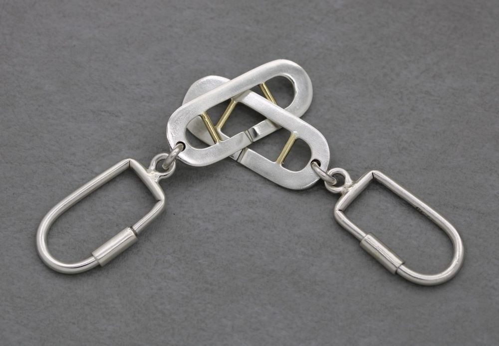 A pair of heavy solid sterling silver interlinking keyrings