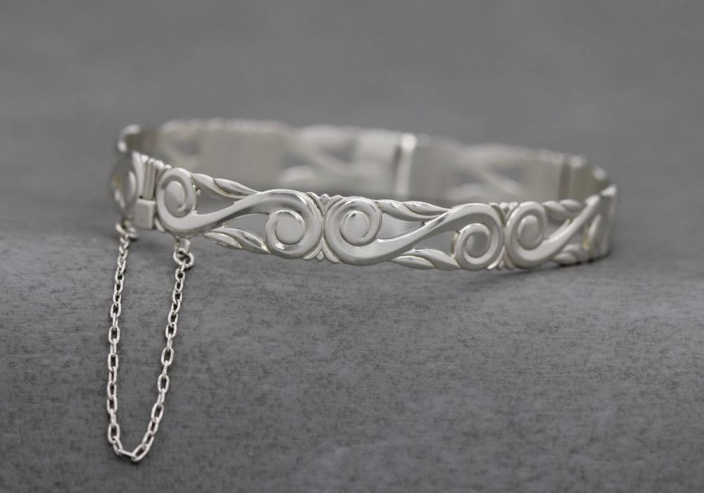 Sterling silver scroll design bangle with safety chain
