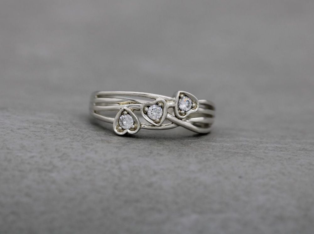 Sterling silver multi-strand effect ring with a trio of clear stoned hearts
