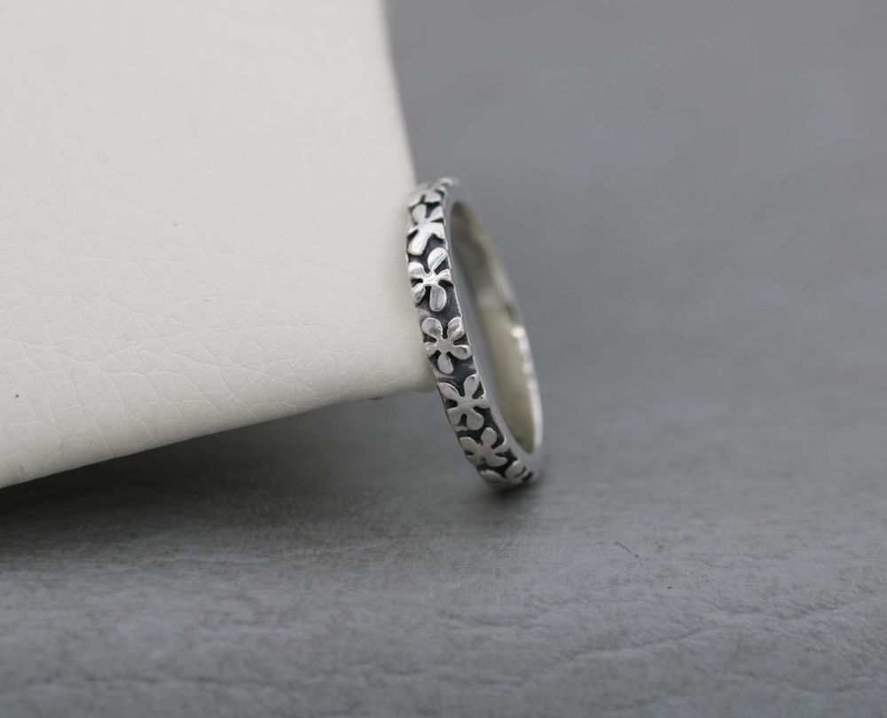 Handmade oxidised sterling silver ring with a raised flower texture