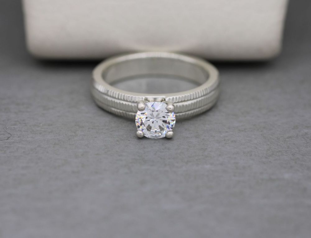 Thick set sterling silver & clear stone solitaire ring with textured should