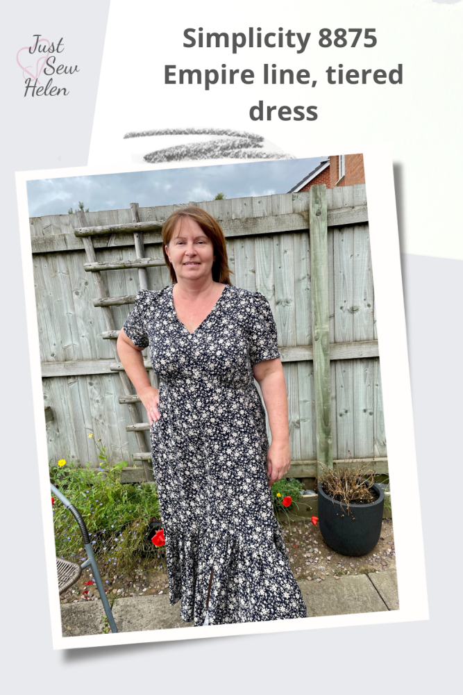 A poster of a lady wearing a dress made using sewing pattern Simplicity 8875. Made with navy and sand flowered fabric, the lady is standing in front of a garden fence