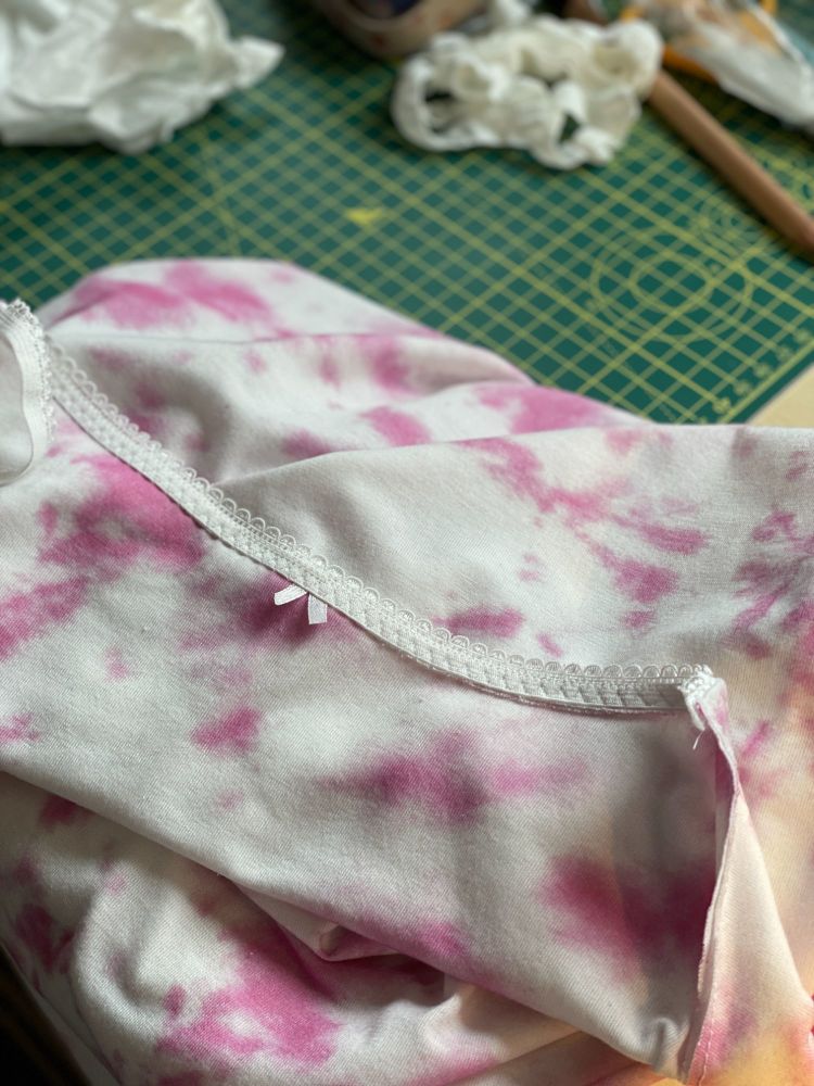 A pink and white camisole with picot edge elastic and a small ribbon in the centre.