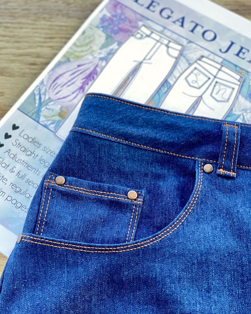 Close up photo of rivets on a pair of blue jeans 