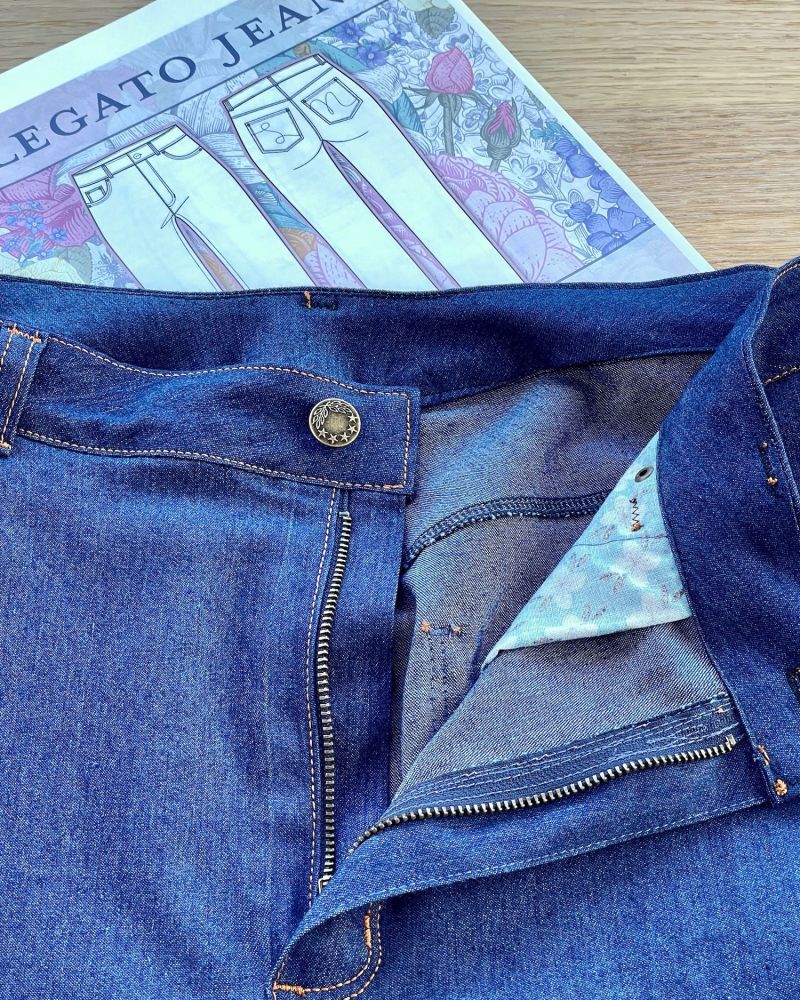 Photo of a pair of blue jeans showing the metal zipper and button