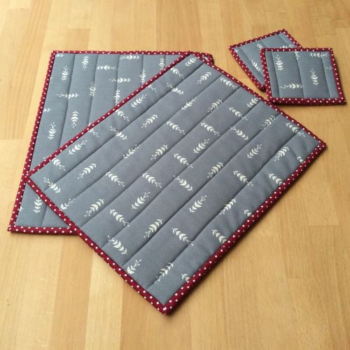 A Pair Of Quilted Place Mats And Matching Coasters In Grey And