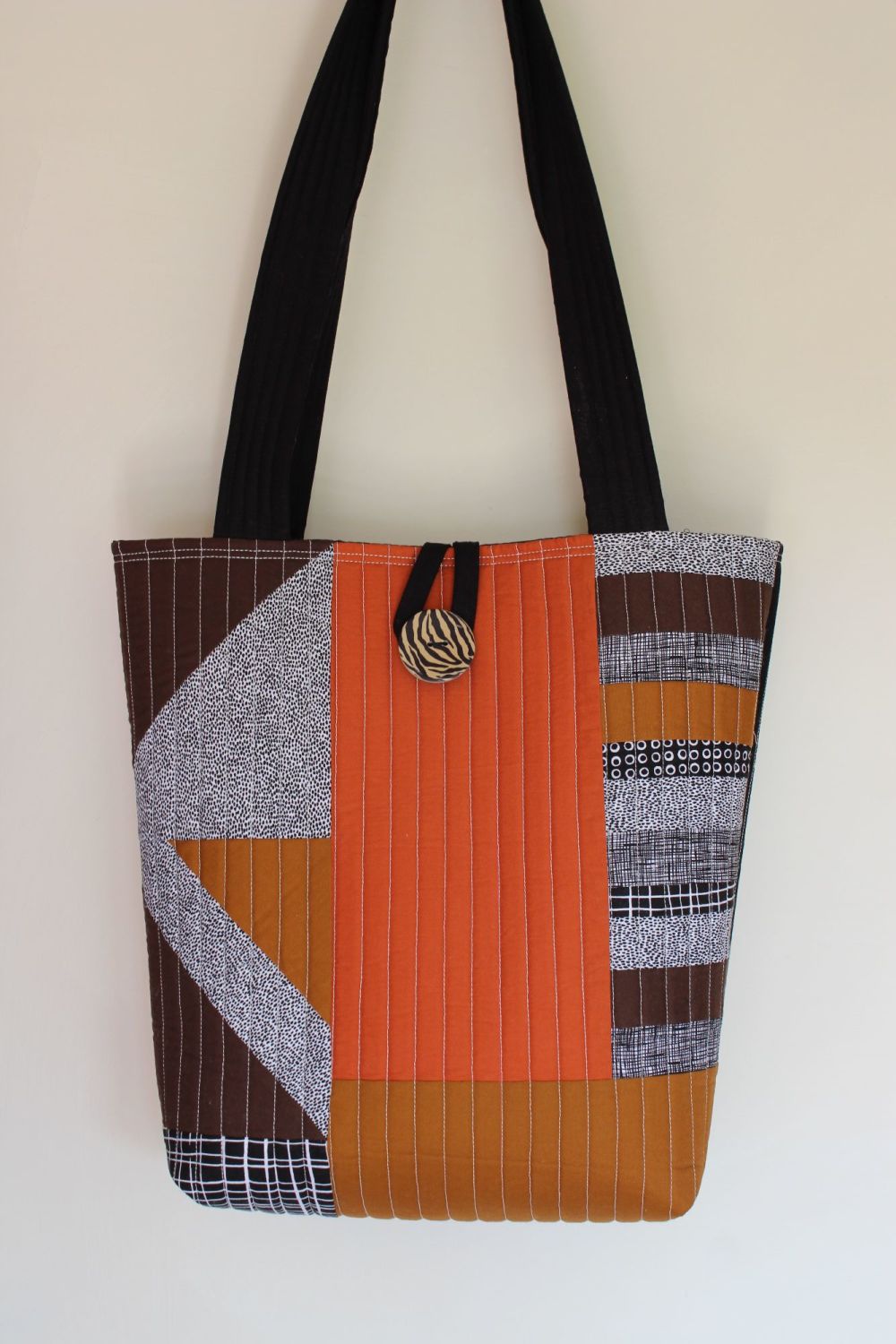 A modern tote bag using a combination of brown fabric in various shades ...