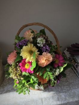 Basket fresh seasonal flower arrangement - various colours of a seasonal flower mix