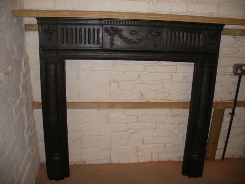 Reclaimed Victorian cast iron fireplace surround with stripped pine shelf.