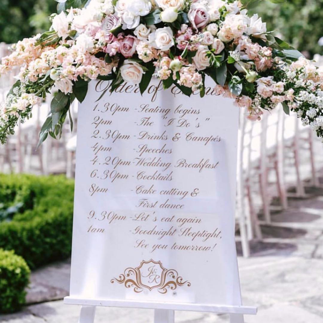 frosted acrylic order of events with gold detail and wedding monogram