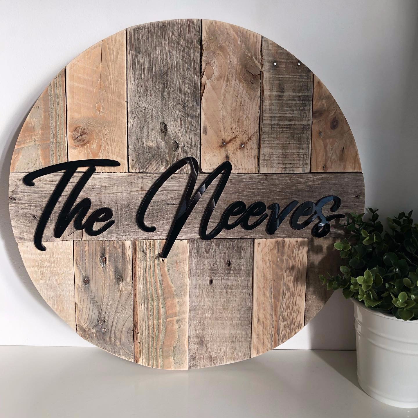 Black laser cut lettering on reclaimed pallet wood backing